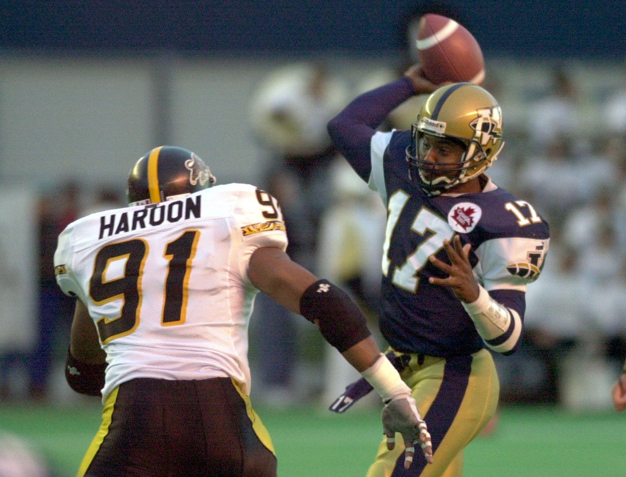 2D3NJMB Winnipeg Blue Bombers quarterback Khari Jones (17) gets the pass away as Hamilton Tiger-Cats Idris Haroon (91) puts pressure on him during the first half of CFL action in Winnipeg, September 8, 2001. REUTERS/Fred Greenslade

FG